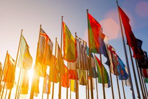 Colorful world international flags waving in the sky at sunset Colorful world international flags waving in the sky at sunset
